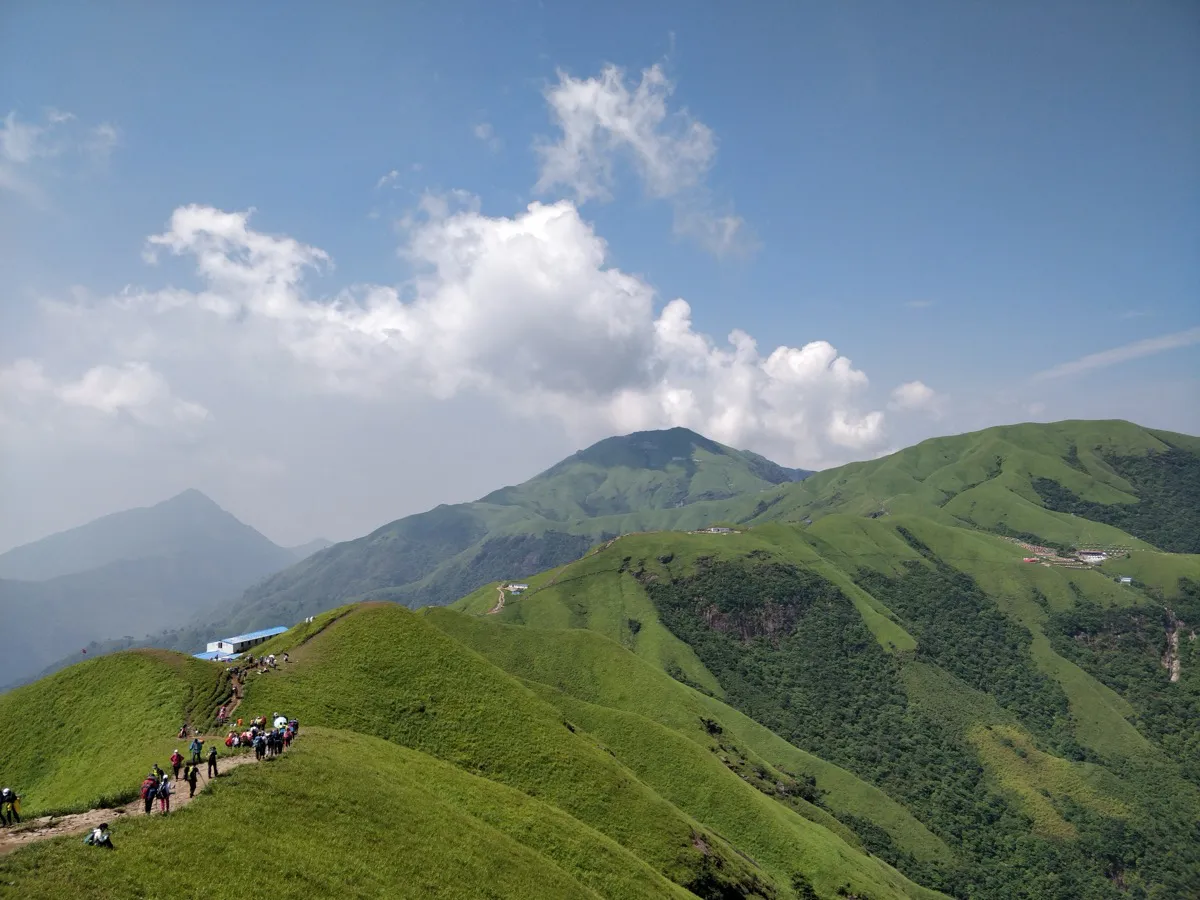 Hikers walking along a narrow ridge trail on Wugong Mountain